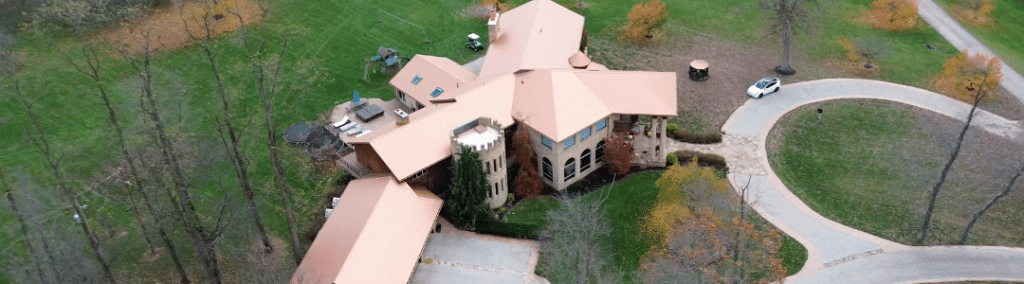 Aerial view of a house with a new metal shingled bronze tinted roof