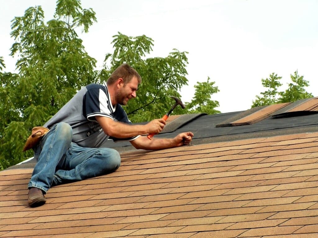 roof worker is installing shingles