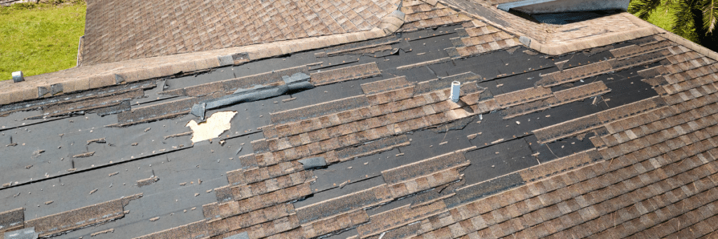 Roof in need of a replacement showing damage from weather with shingles coming off