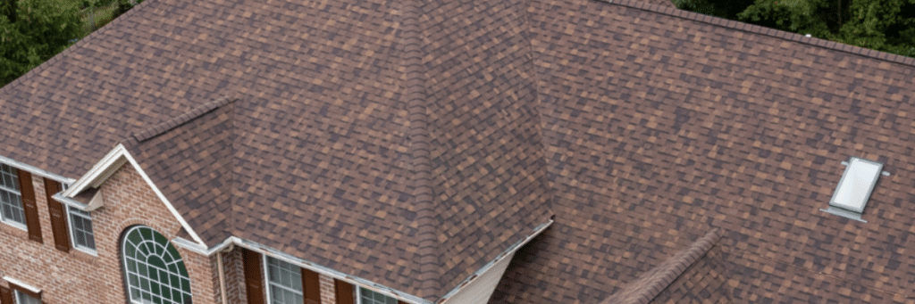 Aerial view of a brick house with red shutters showcasing the new roof