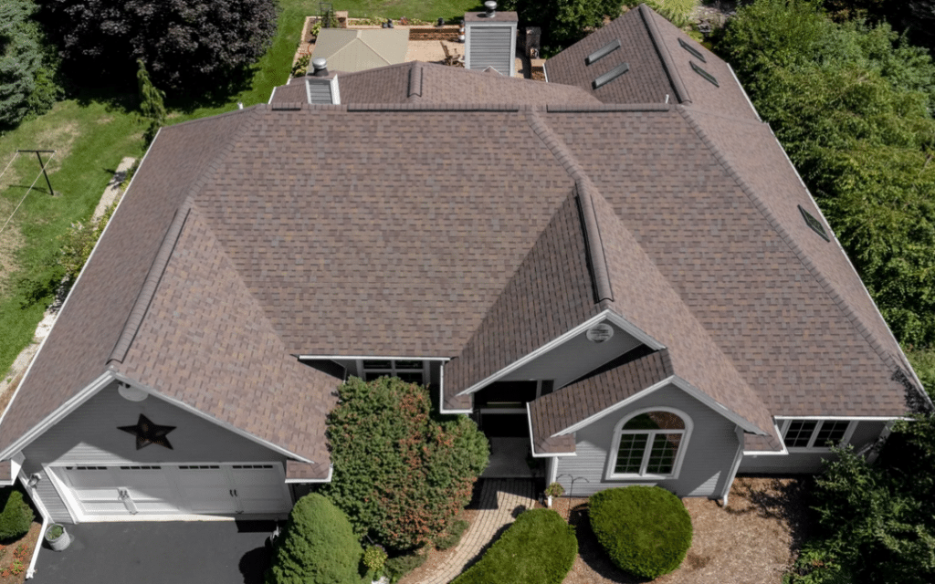 Aerial view of a brick house with red shutters showcasing the new roof