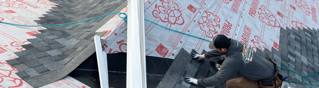 Close up of a man working on replacing a roof with part of the roof already replaced