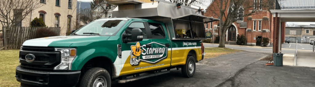 The yellow and green Starway roofing truck at a jobsite