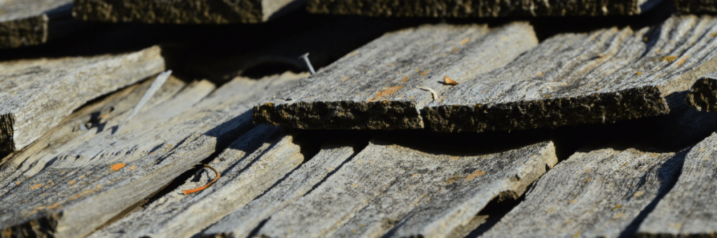Old roof in need of a replacement showing damage from weather with shingles coming off