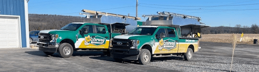 two Starway Roofing trucks sitting in parking lot