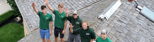 Starway Roofing workers standing on a roof they are working on smiling and waving